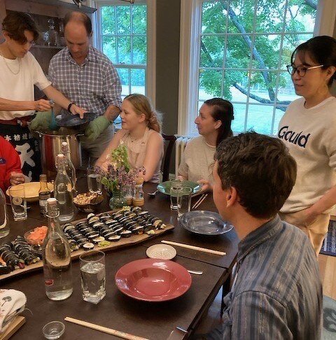 教職員に寿司をふるまう佐久間さん(写真左)